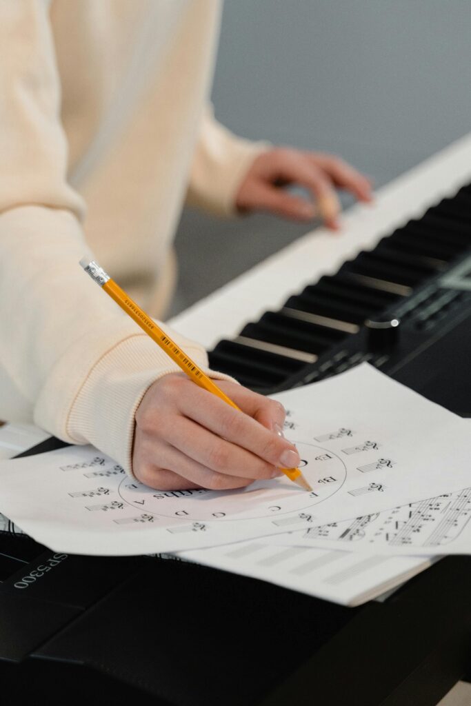 pexels-photo-6670748-6670748 Creating music sheets while playing piano. Perfect for education and creativity themes.